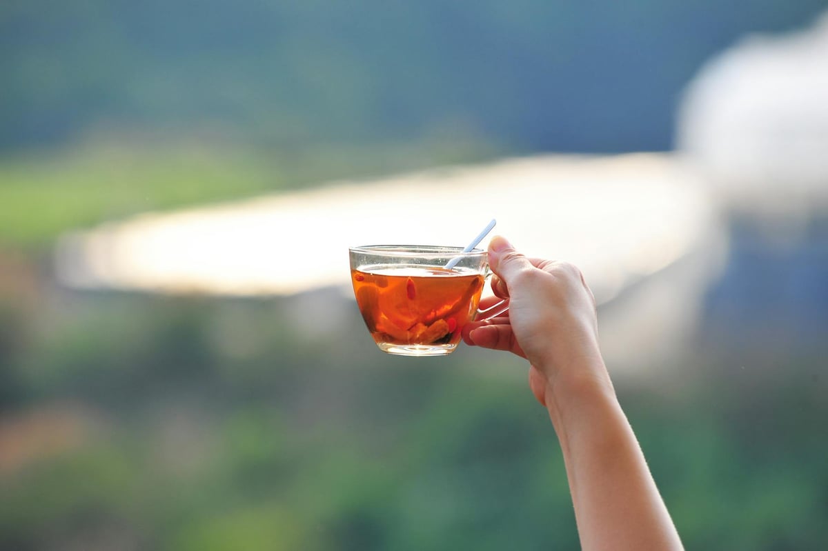 A peaceful moment enjoying tea outdoors with a beautiful blurred background.